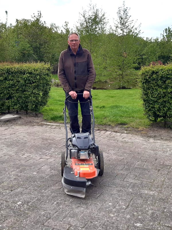 Bert Kruijer met zijn borstelmachine voor een schoon terras